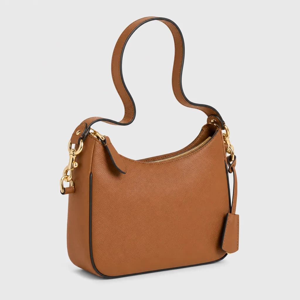 Tan leather handbag isolated on a transparent background with a soft cast shadow